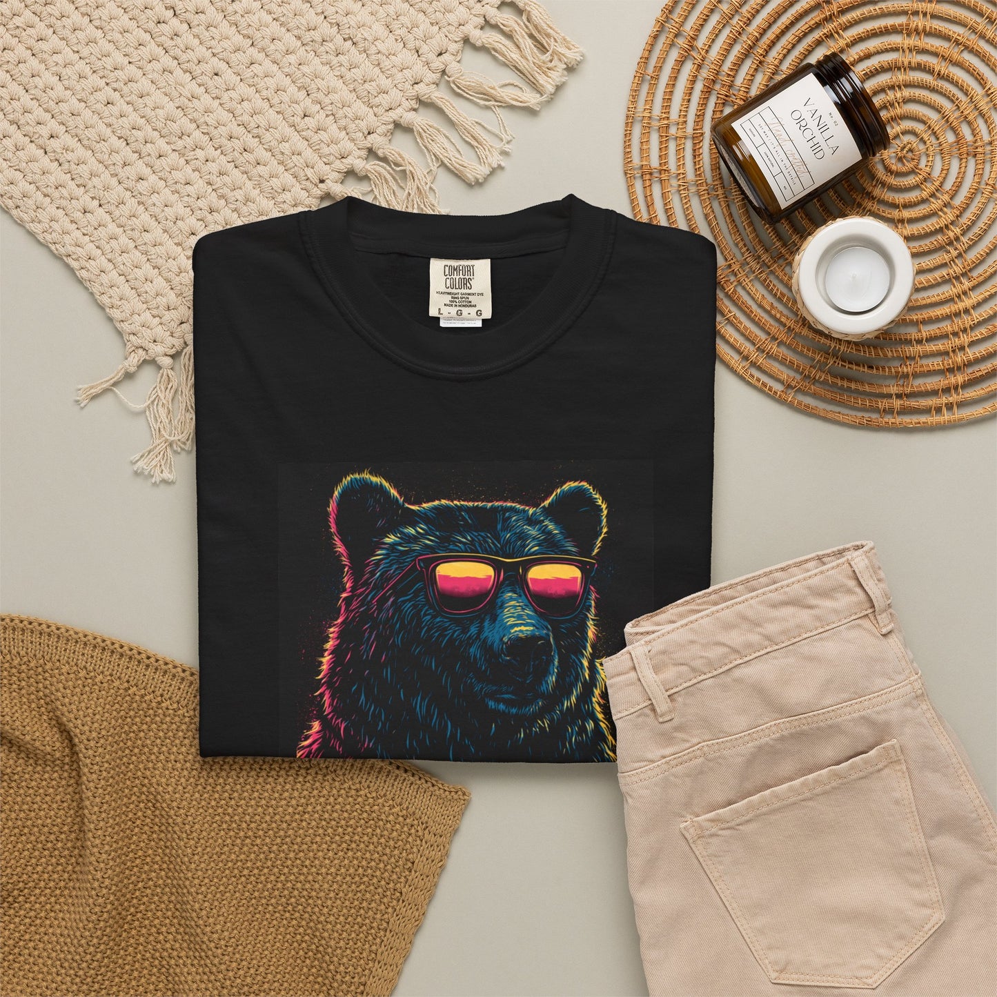Unisex Beer Can T-shirt featuring a colorful bear graphic wearing sunglasses, displayed with beige pants and accessories.