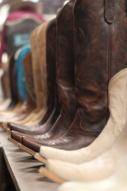 A row of cowboy boots lined up on a shelf