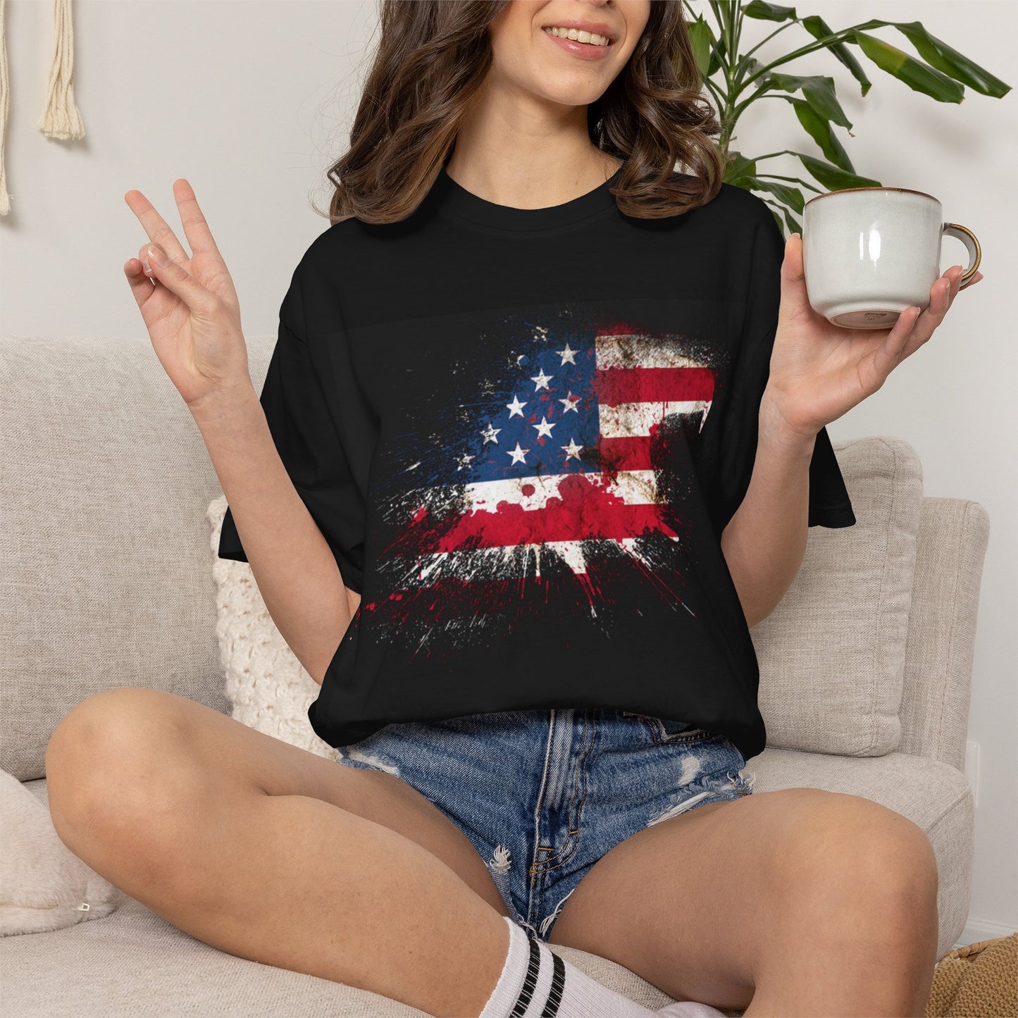 Unisex Garment-Dyed T-shirt featuring a distressed American flag design, model sitting with a mug.