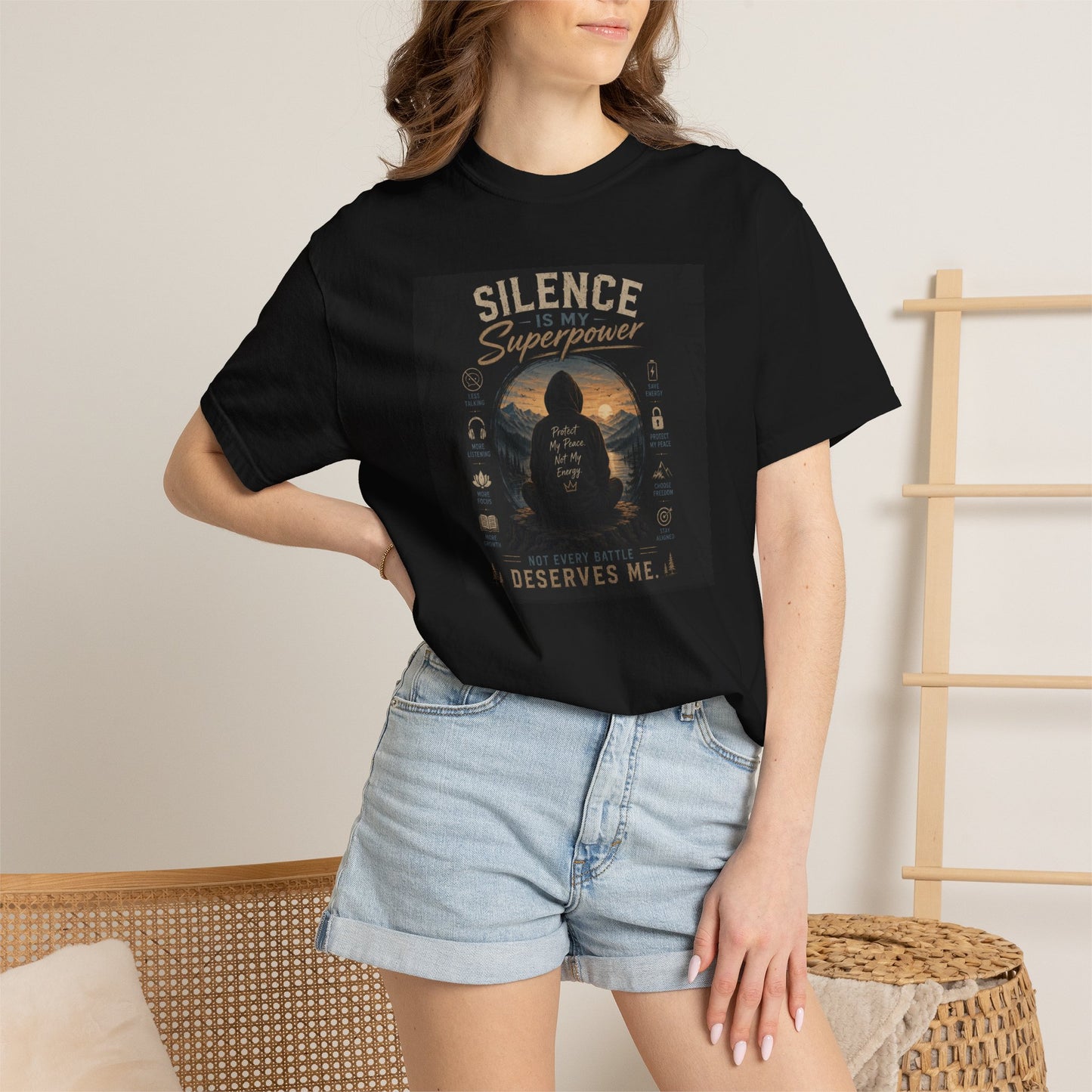 Black t-shirt featuring "Silence Is My Superpower" graphic, worn by a model with denim shorts, set in a cozy room.