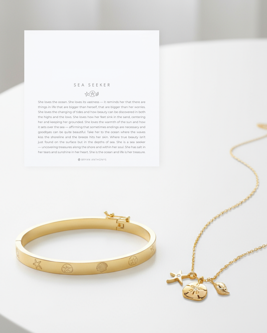 Gold Sea Seeker Bundle featuring a charm necklace and bracelet with ocean-themed designs, accompanied by a descriptive card.